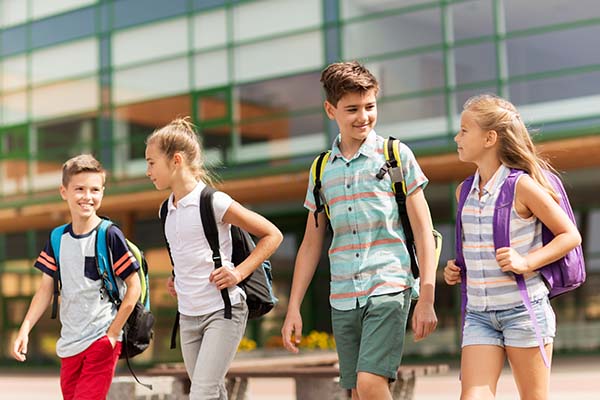 Kids walking home after school with safety and security window film installed.